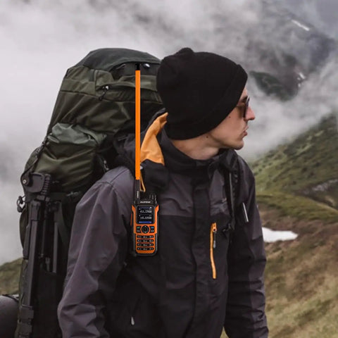 Hiker with backpack using Orange SMA-Female Tactical Ham Radio Antenna 18.8 Inch Foldable For 144 To 430 MHz VHF UHF