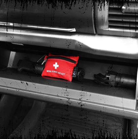 Lightning X Mini First Aid Kit red compact 20-piece emergency pouch with carabiner in a car trunk