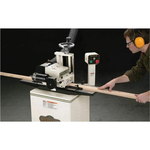 Badass Two Hp Planer Molder With Stand And Power Feed 220 Volt Woodworking Beast in use with wood plank.