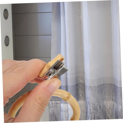 Close-up of a hand holding a khaki ring and clip, part of 2 Pack Curtain Rings With Clips Anti Slip Shower Drapery Hooks For Stable Curtain Suspension And Smooth Glide Rod Round Design Easy Install Durable No Snag.