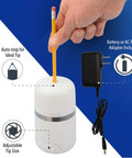 Two In One Battery And Electric Fully Automatic Pencil Sharpener For Regular Graphite And Drawing Pencils With Auto Feed And Auto Eject Adjustable Tip Size Includes AC Adapter Office And School Use White, shown with a pencil and power adapter.