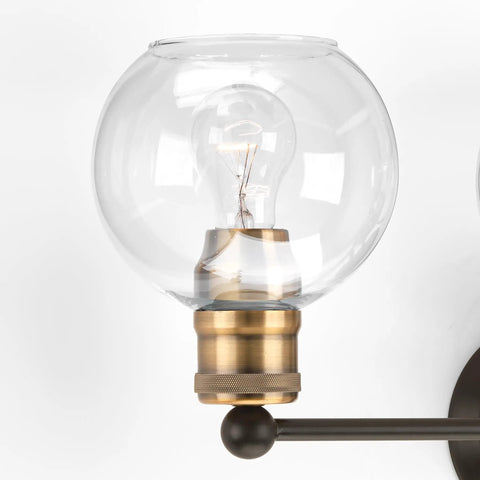 Close-up of clear glass globe on Coastal 3 Light Bath Vanity Light With Clear Glass Globes In Antique Bronze Finish.