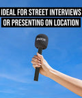 Interview GO Handheld Adaptor For Wireless ME GO And PRO Transmitters held against blue sky with removable windshield and handle