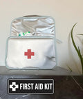 Open first aid kit with visible medical supplies and red cross, plus First Aid Kit Sign Navy Blue And White Small Durable Plastic.