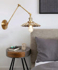 Badass Heavy Duty Swing Arm Wall Lamp, Adjustable Bronze Sconce above a cozy bed with a nightstand.