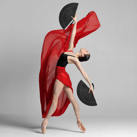 Black Hand Fan For Stage And Rave Dancers With Elaborate Design And Satisfying Snap Clack Go To Handheld Fan For Line Dancers 13 Inch Closed Size For A Bold Onstage Statement with dancer in red flowing attire