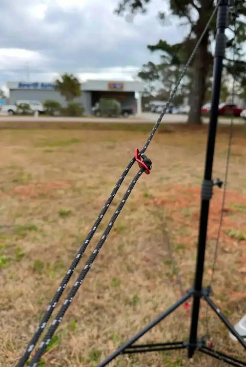 Tall Tripod Stabilization Kit For TST 20 With Aluminum Stakes, showcasing guy wire clamp and nylon ropes in outdoor setup.