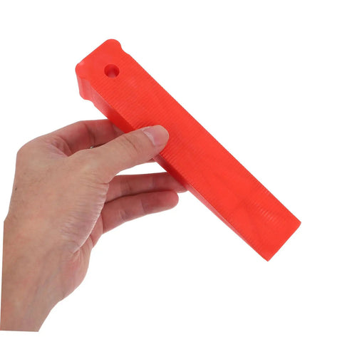 Red Plastic Leveling Wedges And Reusable Gap Filler Shims For Bullseye Door And Window Alignment held in hand for DIY projects.