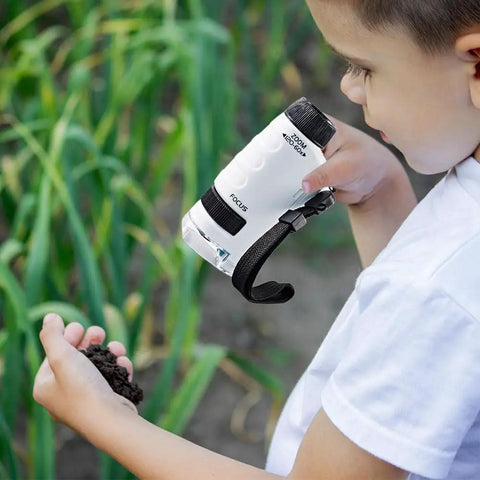 Kid Friendly Pocket Microscope Kit With High Magnification 2026 used by child examining soil outdoors, white portable science tool.