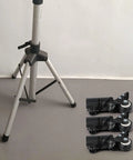 L-Shaped Speaker Tripod Casters with Silent Ball Bearings beside a tripod on a grey floor, showcasing design and installation setup.