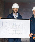 Three construction workers wearing hard hats holding 36x48 blueprint using Built Different Tough Blueprint Cover Protector.