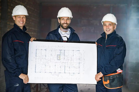 Three construction workers wearing hard hats holding 36x48 blueprint using Built Different Tough Blueprint Cover Protector.