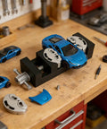 Dual Jaw Mini Vise Clamp With Fractal Jaw That Auto Adapts To Irregular Shapes For Mad DIY Projects holding a toy car on a workbench.