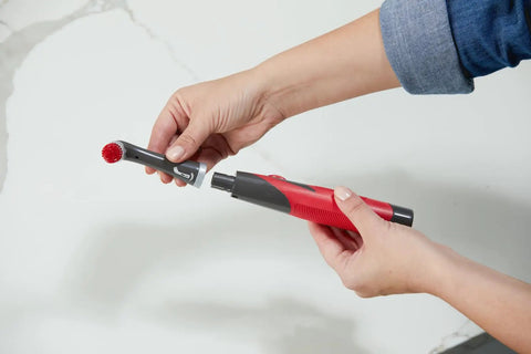 Attachable Grout Head For Cordless Power Scrubber Battery Powered Scrub Brush Attachment being attached with two hands