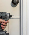 Using a drill with a Top Shelf Exterior Trim Screw Nine By Three Inch Bronze Self Drilling Wood Fastener on a door frame.