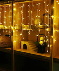 Warm White LED Icicle String Lights For Windows And Outdoor Spaces 16.4Ft 216 LEDs glowing on shelves indoors