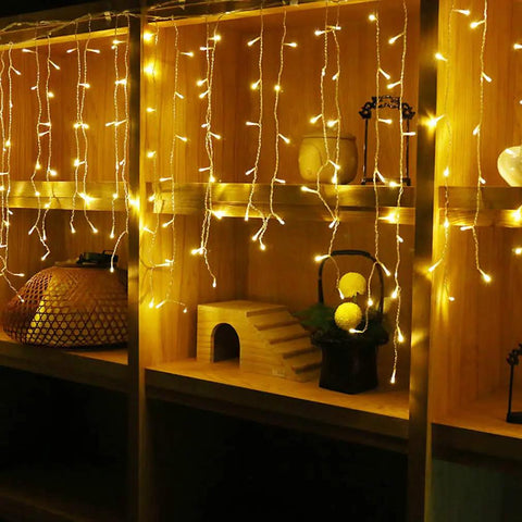 Warm White LED Icicle String Lights For Windows And Outdoor Spaces 16.4Ft 216 LEDs glowing on shelves indoors