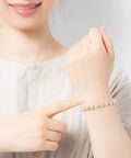 Woman wearing bracelet made with 800 Pcs 6mm Flower Spacer Beads Multicolor Daisy Flower Metal Alloy Spacers For DIY Jewelry Making