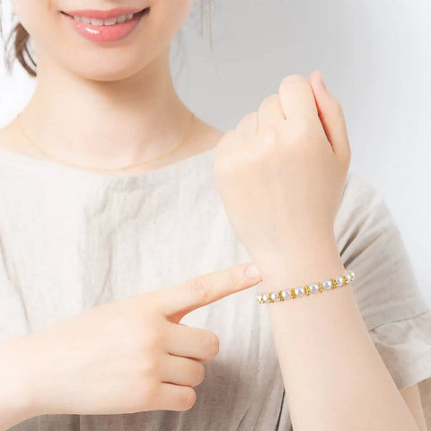 Woman wearing bracelet made with 800 Pcs 6mm Flower Spacer Beads Multicolor Daisy Flower Metal Alloy Spacers For DIY Jewelry Making
