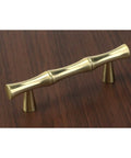 Set Of Four Bamboo Shape Cabinet Pulls In Brushed Gold Finish With Center Hole 2.5 Inches Including Screws 3.7 Inch Total Length Durable Zinc Alloy Drawer Pulls For Kitchen And Furniture, shown installed on wood surface