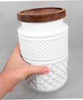 Hand holding a Two Pack Glass Storage Jar With Secure Airtight Lids For Coffee Beans And Dry Goods Keeps Your Stash Locked Down Tight.