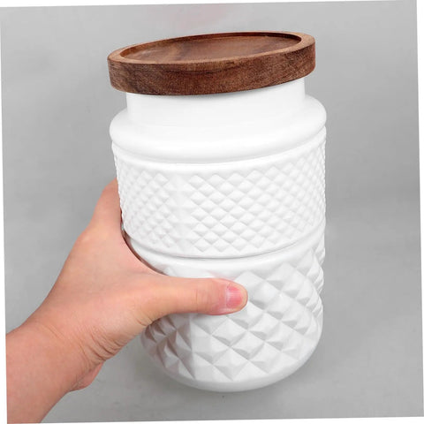 Hand holding a Two Pack Glass Storage Jar With Secure Airtight Lids For Coffee Beans And Dry Goods Keeps Your Stash Locked Down Tight.