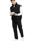 Mens Fleece Lined Winter Vest Windproof Water Resistant Outerwear with secure pockets in black worn by man holding a tablet.
