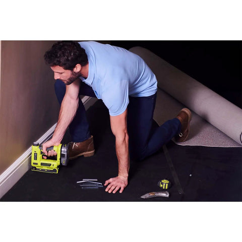 Man using Heavy Duty Cordless Electric Stapler Beast For Upholstery Carpet Home Decorative Projects on a carpet.