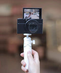Person holding MT-08 White Mini Tripod For Camera With 1 Quarter Inch Mount 2 In 1 Extendable Handheld Video Stand