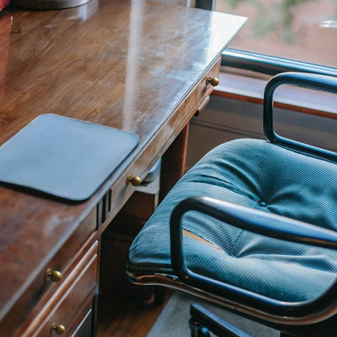 Set Of Twelve Sleek Round Antique Brass Cabinet Knobs For Rustic Modern Kitchens And Vintage Furniture Makeovers One And One Eighth Inch Diameter Durable Hardware For Cabinets Drawers And Dressers With Bold Rustic Charm visible on wooden desk drawers and chair.