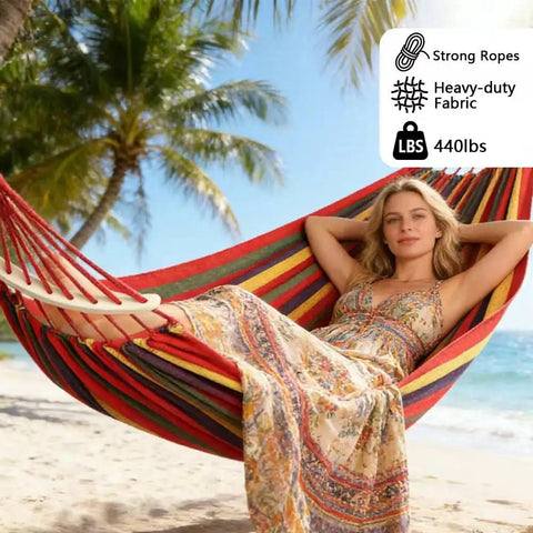 Woman relaxing in Rainbow Cotton Canvas Hammock With Tree Straps And Bar, ultra comfy durable fabric, supports up to 440 lbs.