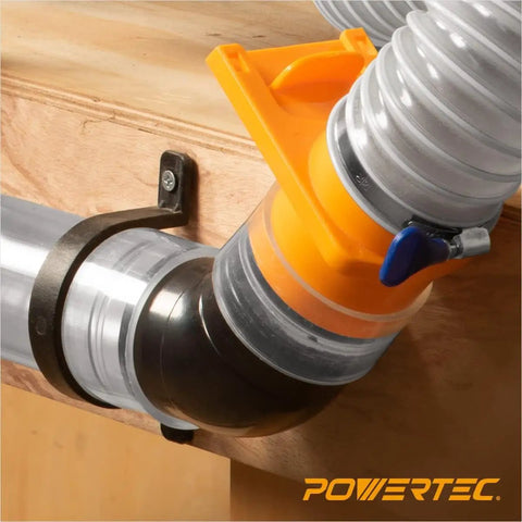 Heavy Duty Flexible Clear Dust Collection Hose Kit Featuring 4 Inch By 20 Feet Tubing Cone Reducer Elbows Fittings And Blast Gates connected to workshop table, showing elbow fitting and clamps.