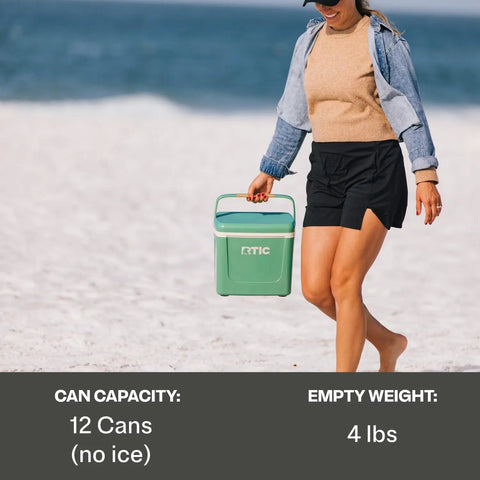 Person carrying Road Trip 8 Qt Personal Cooler Compact And Lightweight Insulated Ice Chest That Fits Up To 12 Cans on beach.