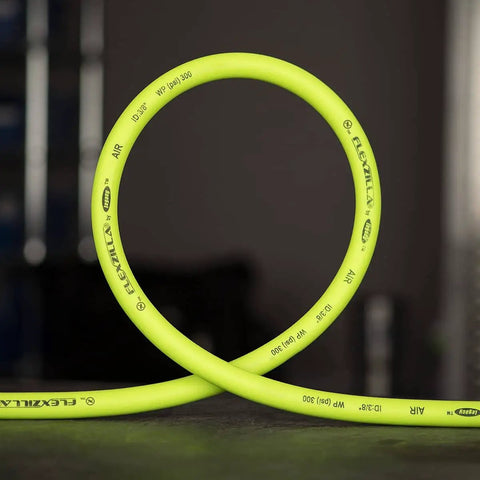 Heavy Duty 3/8 Inch Air Hose 50 Ft Lightweight Hybrid Polymer All Weather Flex From -40 To 140 Degrees Field Repairable Aluminum Fittings Abrasion Resistant Outer Cover Crush Resistant Ends ZillaGreen shown coiled up on a concrete floor.