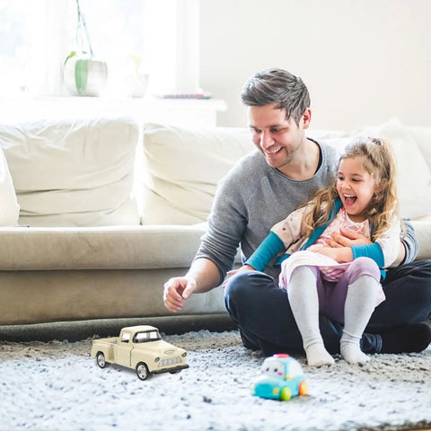 Father and daughter playing with Small Off Road Pickup Truck Model Toy Figure For Kids And Collectors on living room carpet