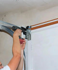 Number 14 Three Quarter Inch Serrated Hex Washer Head Self Drilling Tek Screws Zinc Plated Metal Fasteners attached to garage door track.