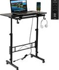 Total Game Changer Small Height Adjustable Standing Desk With Tiltable Tabletop And Smooth Rolling Wheels, black mobile desk with laptop and headset.