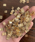 Hand holding a set of 1:12 scale miniature door hinges with screws, designed for dollhouse doors and cabinets, DIY projects, mini decor.