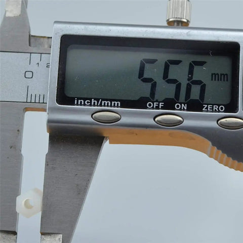 Measuring Real Deal White Nylon Hex Standoff 100 Pack M3x12mm with digital calipers showing 556 mm.