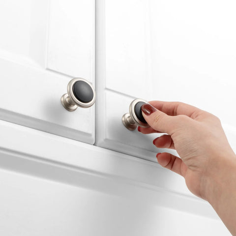 Hand reaching for round cabinet knobs 10 pack matte black and nickel, durable solid metal drawer knobs on white cabinet.