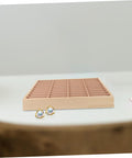Slick Multi Grid Jewelry Tray Wooden Desktop Organizer Phone Stand For Rings Earrings And Bracelets on white table with earrings.