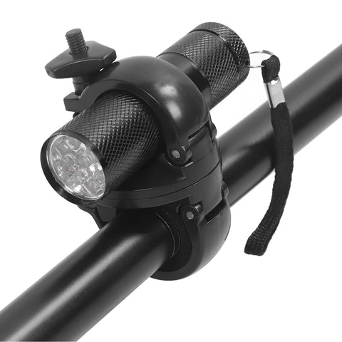 Mounted flashlight holder on bicycle handlebar with secure clamp mechanism.