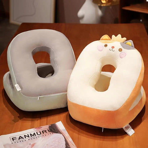 Two nap pillows with kawaii duck design on a wooden table, gray and orange, featuring hole in center for neck support