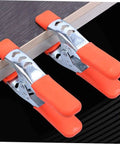 Heavy Duty Metal Spring Clamps With Ergonomic Handles Built Tough For Woodworking Carpentry And Model Making Red Coated Shop Essentials showing two orange clamps securing wood.