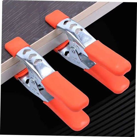 Heavy Duty Metal Spring Clamps With Ergonomic Handles Built Tough For Woodworking Carpentry And Model Making Red Coated Shop Essentials showing two orange clamps securing wood.