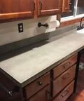 Heavy Duty Water Based Concrete Countertop Sealer With Slick Matte Finish And Food Safe Shield In A Tough Four Pack Kit For Quick Apply shown on kitchen counter.