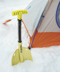 Grab And Go Collapsible Snow Shovel For Camping And Car Emergency Kit next to orange tent in snow, black handle, yellow blade