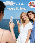 Person using Pocket 2.5K Video Recorder With 180 Degree Rotating Lens For Vlogging by the sea, handheld POV camera capturing two people.