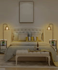 Bedroom setup with two No Fuss All In One Floor Lamps with tables and shelves, built-in USB ports and outlets, beside a bed.