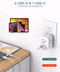 6 In 1 Wall Outlet Expander With USB C And USB A 3 AC Outlets plugged into wall, charging devices on desk